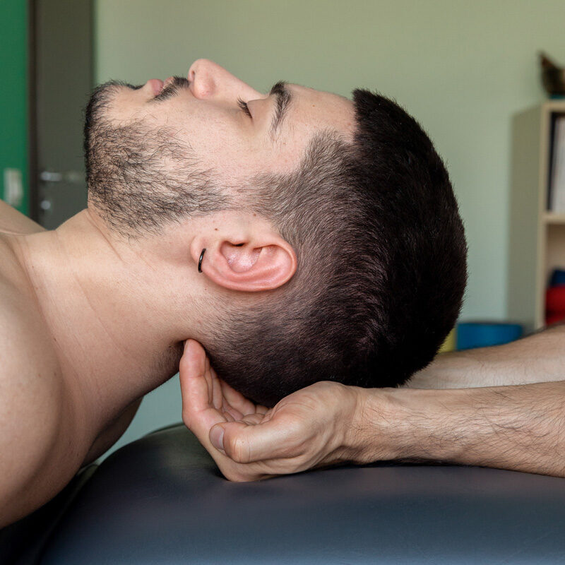 Dottore Dario De Martino effettua una manipolazione al collo su paziente uomo durante un trattamento osteopatico e fisioterapico per la cura del dolore alla cervicale, al collo e al mal di testa